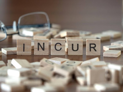 Letters from board game spell out the word “incur” to signify defining it