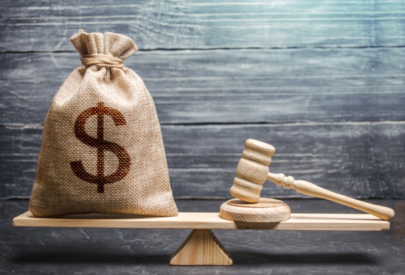 A bag of money and gavel on a scale to represent monetary judgments in subrogation cases